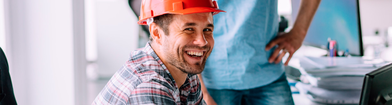 Arbeiter mit Helm im Büro